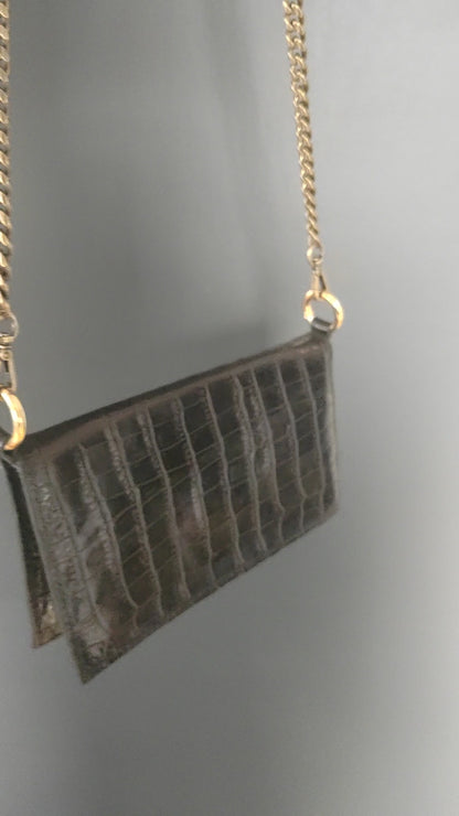 Le sac portefeuille noir en cuir imprimé crocodile